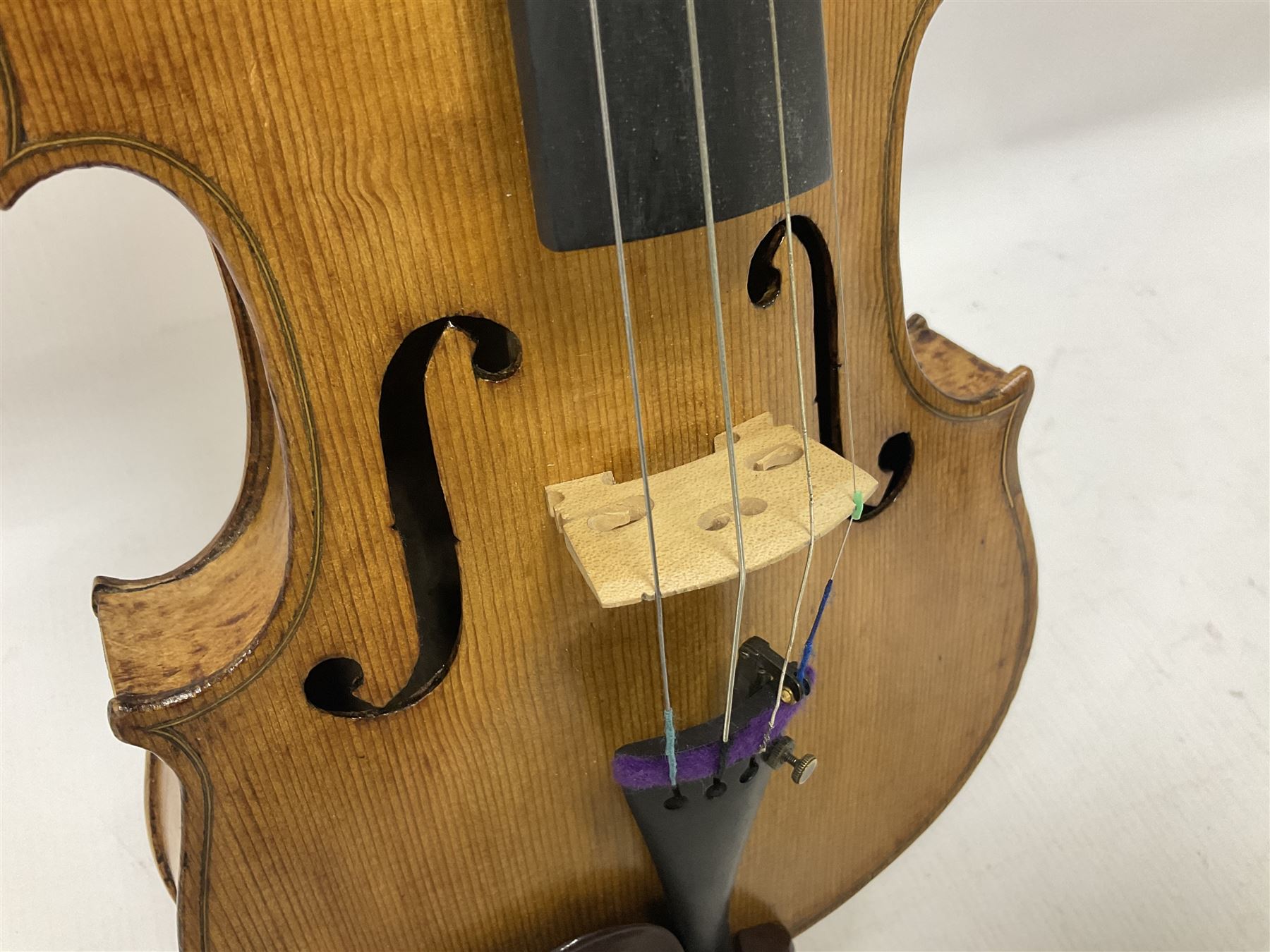 Copy of a full size Stradivarius violin, with an ebonised fretboard, tailpiece and tuning pegs, with a polished chin rest  Length 60cm