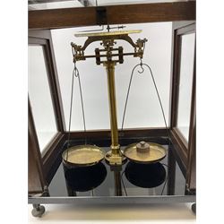 Set of laboratory balance scales by Paul Bunge Hamburg Model 9A No.7977 bearing label for Reynolds & Branson Leeds in mahogany case with upward sliding front door, two hinged side doors, hand cranked rise-and-fall facility and black vitrolite base L36cm H42cm D26cm; and two boxed part sets of weights (3)