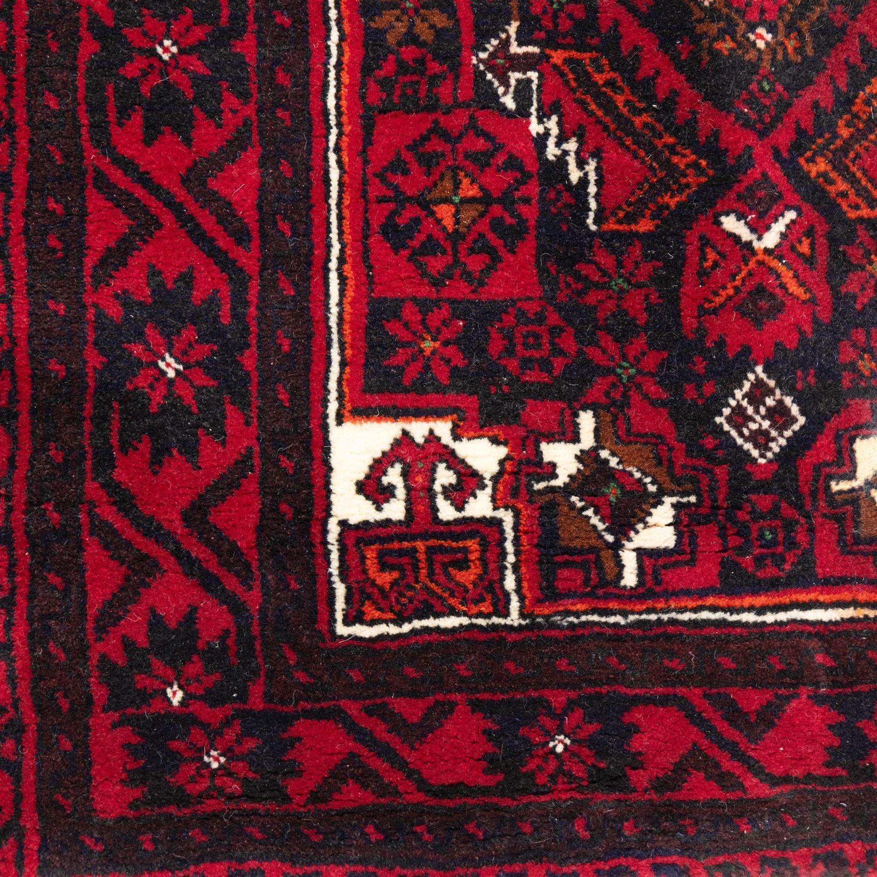 North east Persian Baluch hand-knotted runner, crimson ground with a vertical column of hooked lozenge medallions flanked by stylized leaf motifs within multiple geometric borders of rosettes and angular vines  