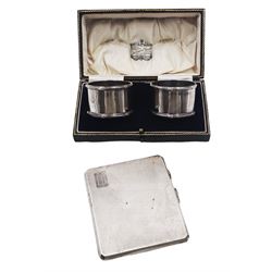 Early 20th century silver cigarette case, of rectangular form with canted corners, engine turned decoration and engraved initials to top corner, hallmarked Frederick Field, Birmingham 1919, together with a pair of 1920's silver napkin rings, hallmarked Adie Brothers Ltd, Birmingham 1924, in velvet and silk lined fitted case, approximate total weight 6.19 ozt (192.4 grams)