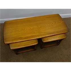  Ercol elm nest of three tables, baluster supports joined by stretchers, W114cm, H40cm, D50cm  