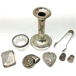 Group of silver, comprising late Victorian vesta case with part ribbed decoration, hallmarked Birmingham 1895, maker's mark worn and indistinct, pair of sugar tongs, hallmarked Birmingham 1936, maker's mark also worn and indistinct, an Edwardian silver mounted candlestick with filled base, hallmarked A E Goodby & Son, Birmingham 1906, small cut glass bowl/open salt with silver mounted rim, hallmarked London, and two hallmarked silver thimbles, plus a base metal snuff modelled as a nautilus shell, and a base metal vesta.