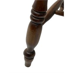 Early 19th century elm farmhouse armchair, the shaped eared cresting rail over tall spindle back, dished seat on turned supports united by H stretchers