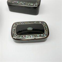 Two 19th century ebonised papier-mâché snuff boxes, with mother of pearl inlay to the hinged opening covers, largest with engraved signature to cover, largest L6.5cm, together with a similar ebonised and mother of pearl papier-mâché tray, D20cm.  