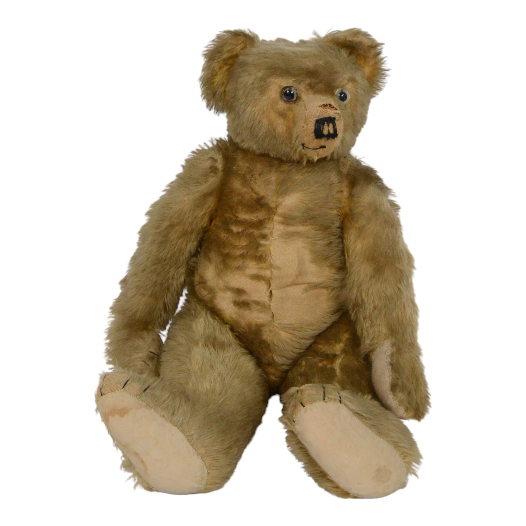 Early 20th century teddy bear, probably German, blonde mohair bear with glass eyes, straw filled snout with stitched nose, hand stitched centre seam, wood wool filled body, jointed limbs, swivel head and hump to back, H67cm