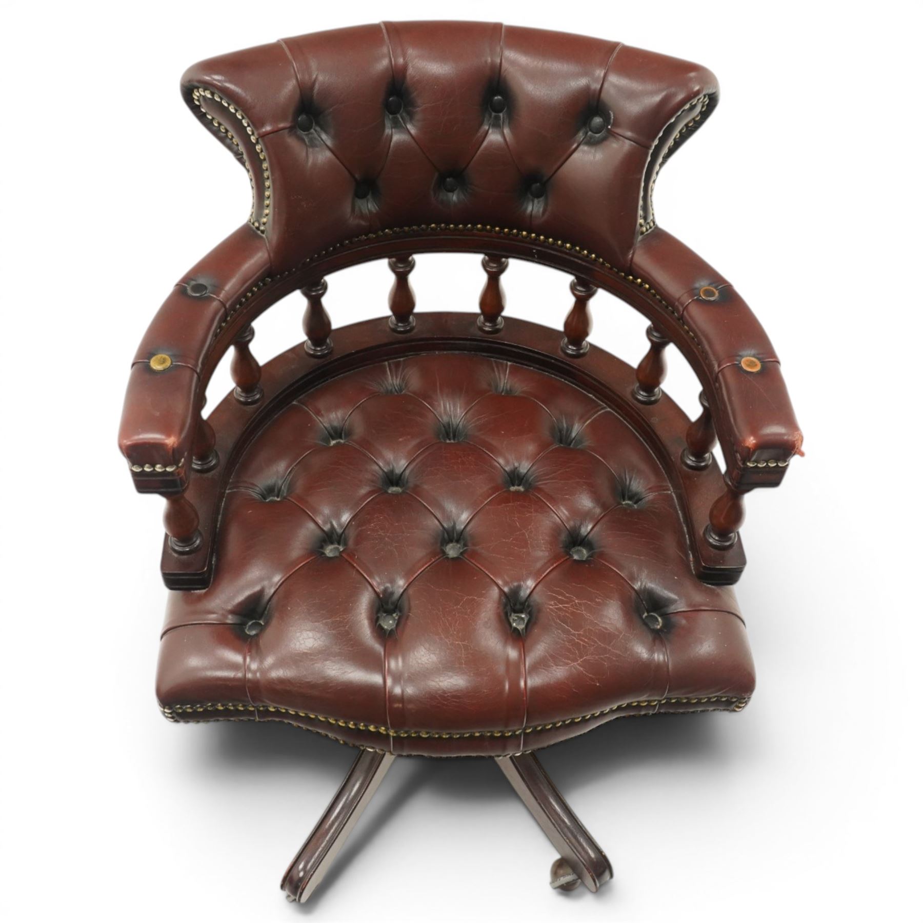 Georgian design captains swivel desk chair, rolled cresting rail over open spindle back on tripod base, upholstered in buttoned oxblood leather
