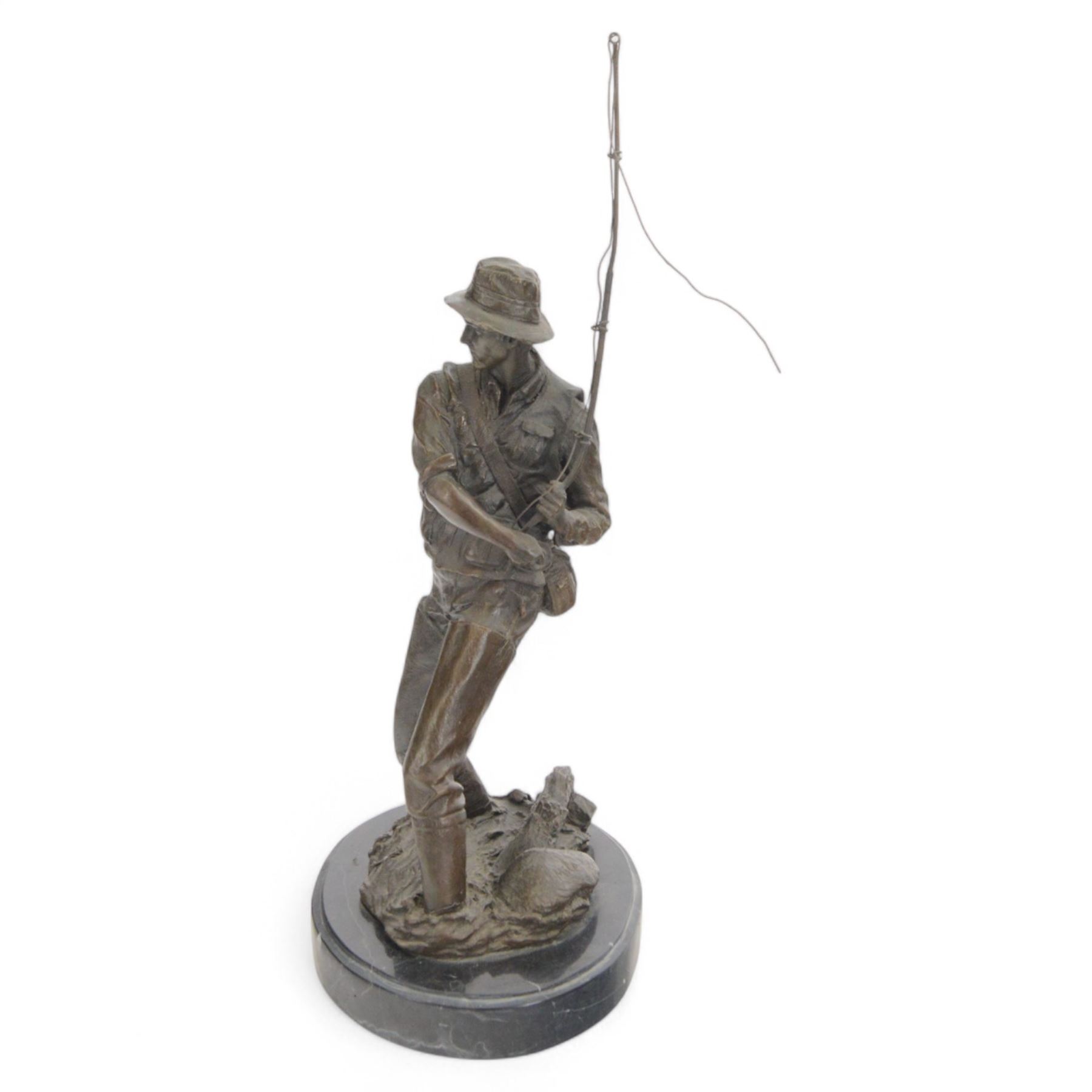 Bronzed figure of a fly fisherman, signed Milo, upon an oval marble base, H42.5cm