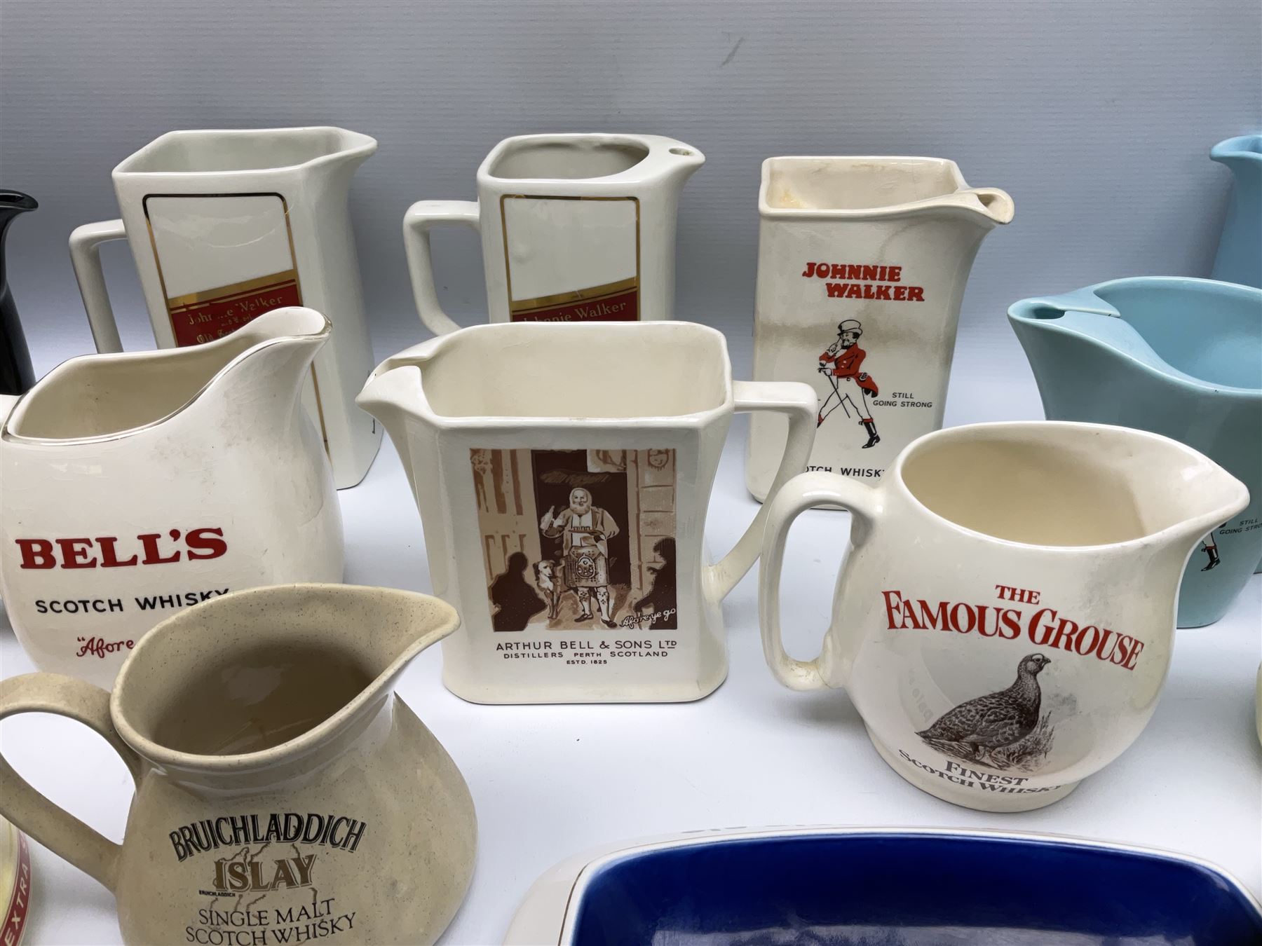 Collection of ceramic pub jugs and ashtrays, including Senior Service ashtray, Bell's old scotch whiskey ashtray,Arthur Bell & sons jug, Beefeater gin jug, two Black and White scotch whiskey jugs, etc    