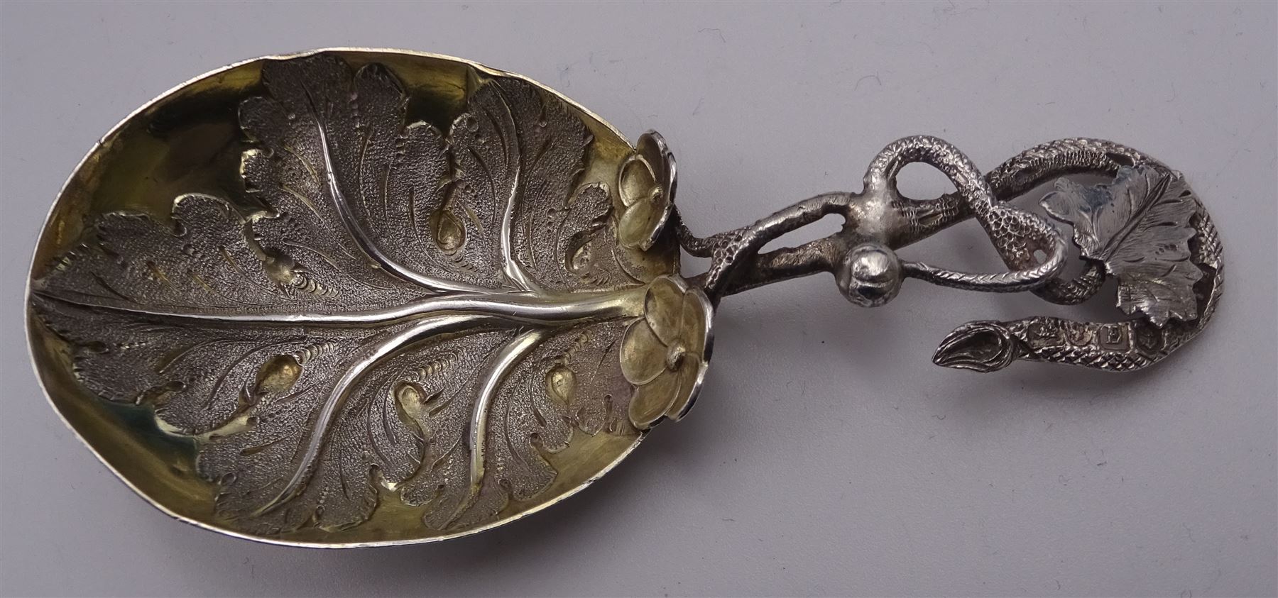 Unusual Victorian silver caddy spoon, the oval parcel gilt bowl embossed with leaf, leading to a flower head mounted tendril handle also detailed with leaf, hallmarked Hilliard & Thomason, Birmingham 1853, L8.5cm, approximate weight 0.49ozt (15.3 grams)