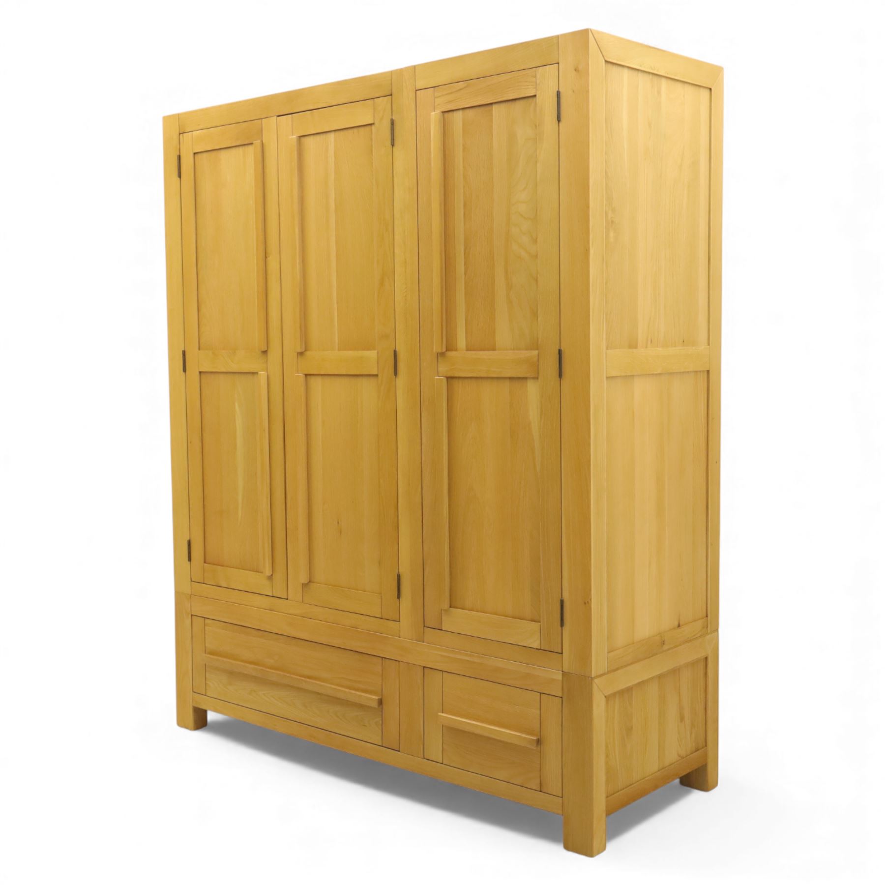 Modern light oak triple wardrobe,  three panel doors with integrated handles enclosing full-height hanging rails, the lower section fitted with two flush-front drawers, square uprights