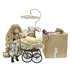Two decorative wicker dolls prams, one with lace parasol,  and eleven dolls, including Leonardo Collection porcelain dolls, tallest pram including parasol H105cm
