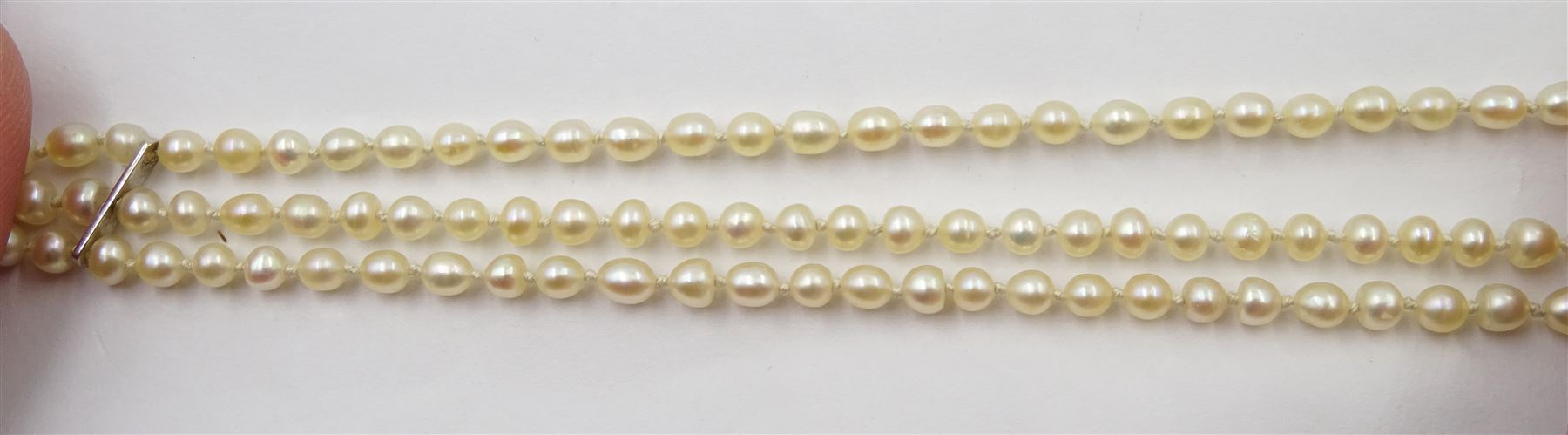 Three strand pearl necklace, with platinum diamond milgrain clasp and a single strand graduating pearl necklace with 18ct white gold clasp set with a diamond