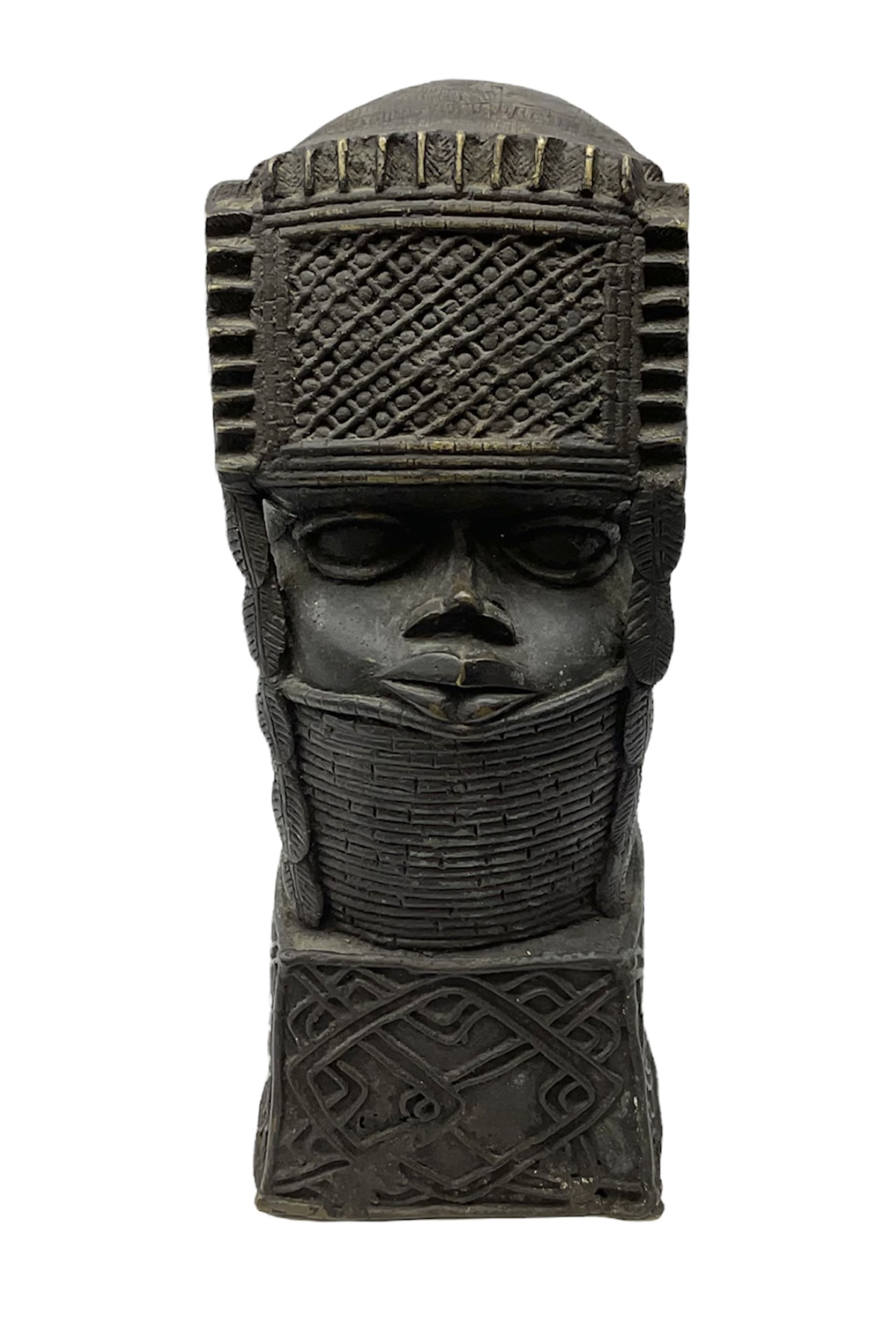 20th century Benin bronze head of an Oba, donning headdress and neck rings with wide open eyes, raised upon a tapering square base, the sides with relief cast knot decoration, H39cm