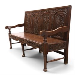 19th century Gothic Revival heavily carved oak settle or hall bench, the high quadruple back with moulded cresting rail over a frieze carved with stylised dolphin and sea creature motifs, the panels decorated with griffin and bird motifs with floral dividing rails, the shaped apron similarly carved with scaly sea beasts, on three cabriole front-supports united by stretchers