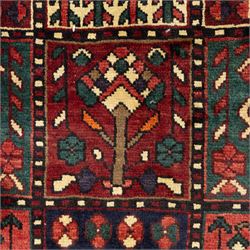 Bakhtiari wool rug, compartmented garden design field with panels of stylised trees, flowers and geometric motifs, enclosed by dark blue main border with repeating floral medallions and guard stripes