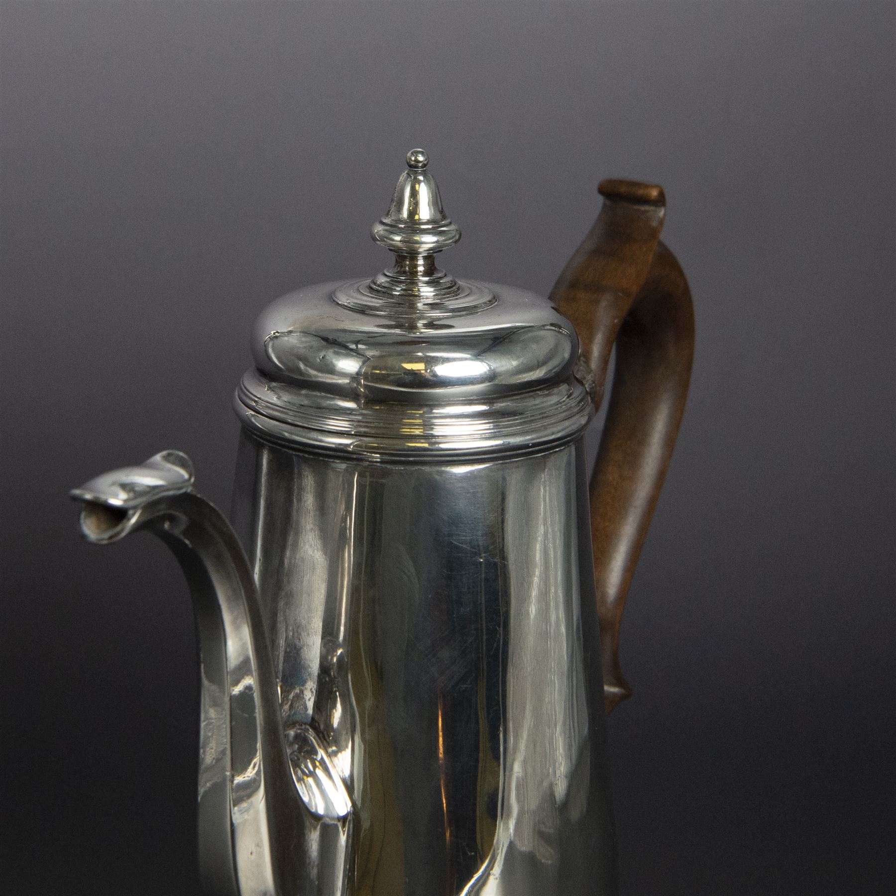 George II provincial silver coffee pot, of tapering cylindrical form, with wooden scroll capped handle, hinged cover with bell finial, and engraved crest to body, hallmarked John Webber of Plymouth, Exeter 1759, H21cm