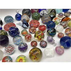 Collection of glass paperweights to include probably Clichy example of rose cane design upon marble base, art glass examples of various sizes and shapes, captured bubble and millefiori designs etc with various makers marks