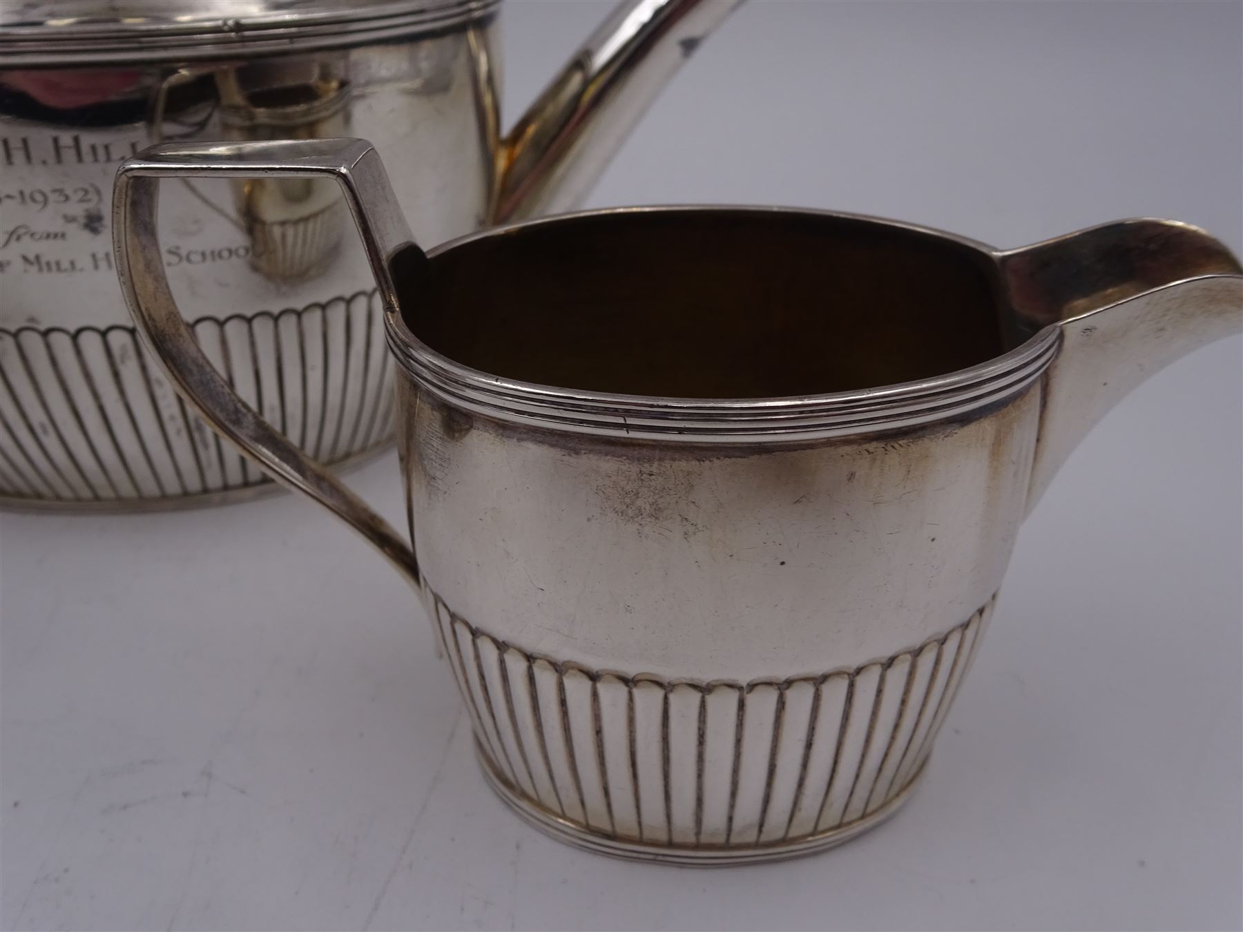 1930s American silver three piece batchelors tea service, comprising teapot, twin handled open sucrier and milk jug, each of part fluted oval form, the teapot with personal engraving to body, wood effect handle and silver urn shaped finial, stamped sterling with maker's mark for Gorham, teapot H13cm