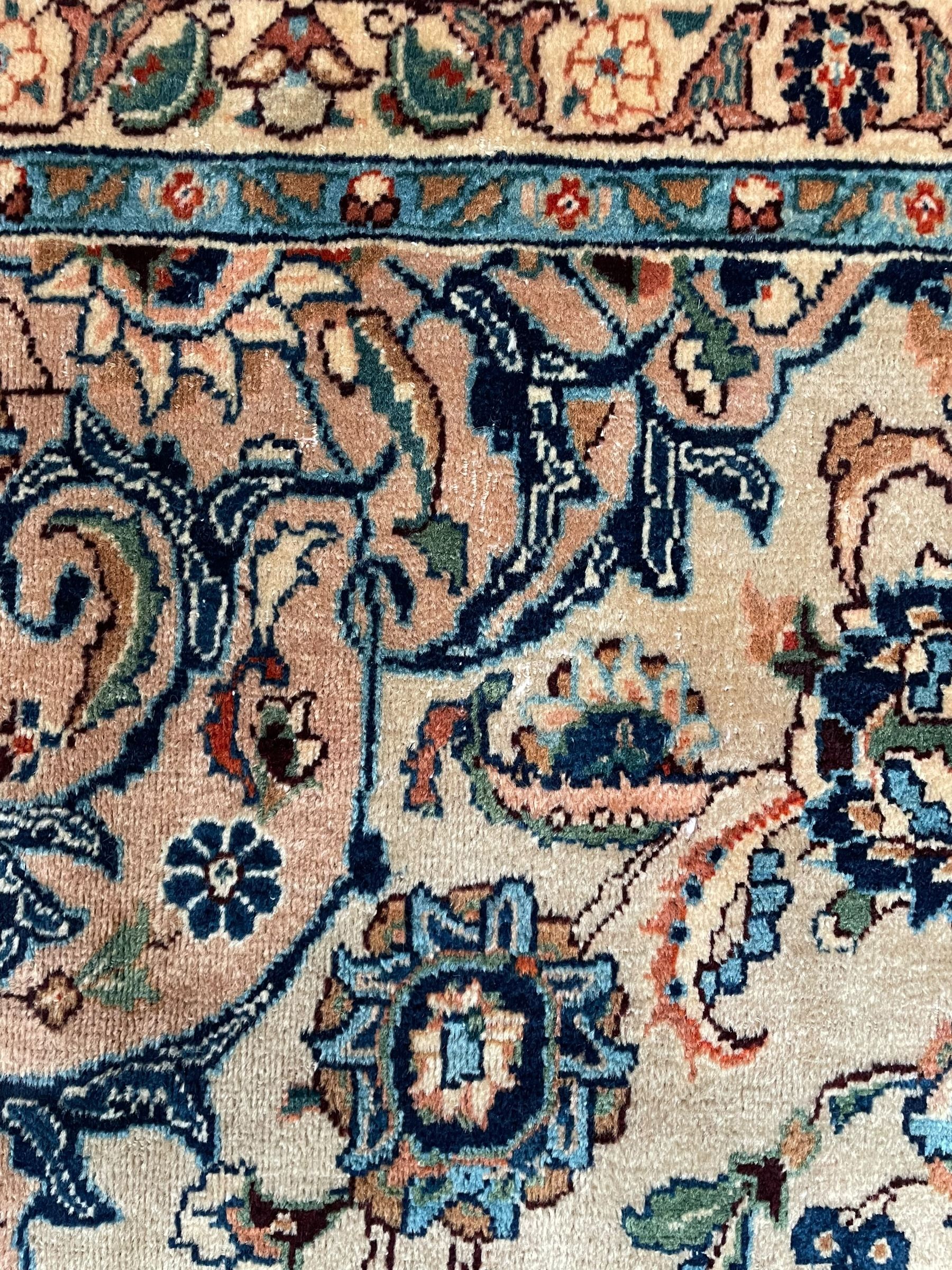 Persian Kashmar camel ground carpet, palmette rosette medallion on a field of curling leafy branches and stylised plant motifs, scrolling border decorated with further palmettes, within floral pattern guard stripes