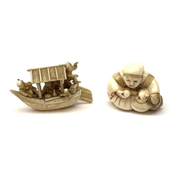 A Japanese carved ivory Netsuke, modelled as a seated figure with monkey companion, signed beneath, H3.5cm, together with a carved ivory model of a traditional boat surmounted by four figures, L6.5cm.