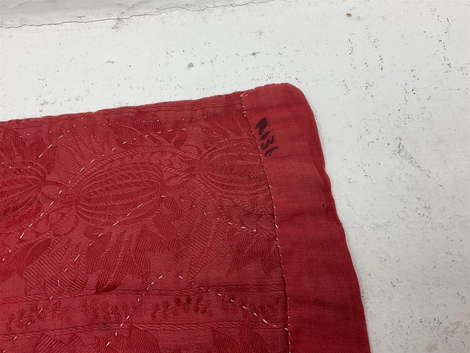 19th century patchwork quilt, hand stitched from hexagons of various materials including printed patterned and floral examples, featuring repeating large central hexagon to centre, the top and bottom with thick panel red jacquard border, the sides bordered with plain red fabric, lined with panels to reverse, 180 x 190 cm