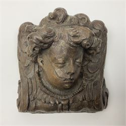 Late 17th century oak ecclesiastical wall plaque, depicting a putti mask, together with a similar 18th century wall bracket, tallest H18cm, W15.5cm