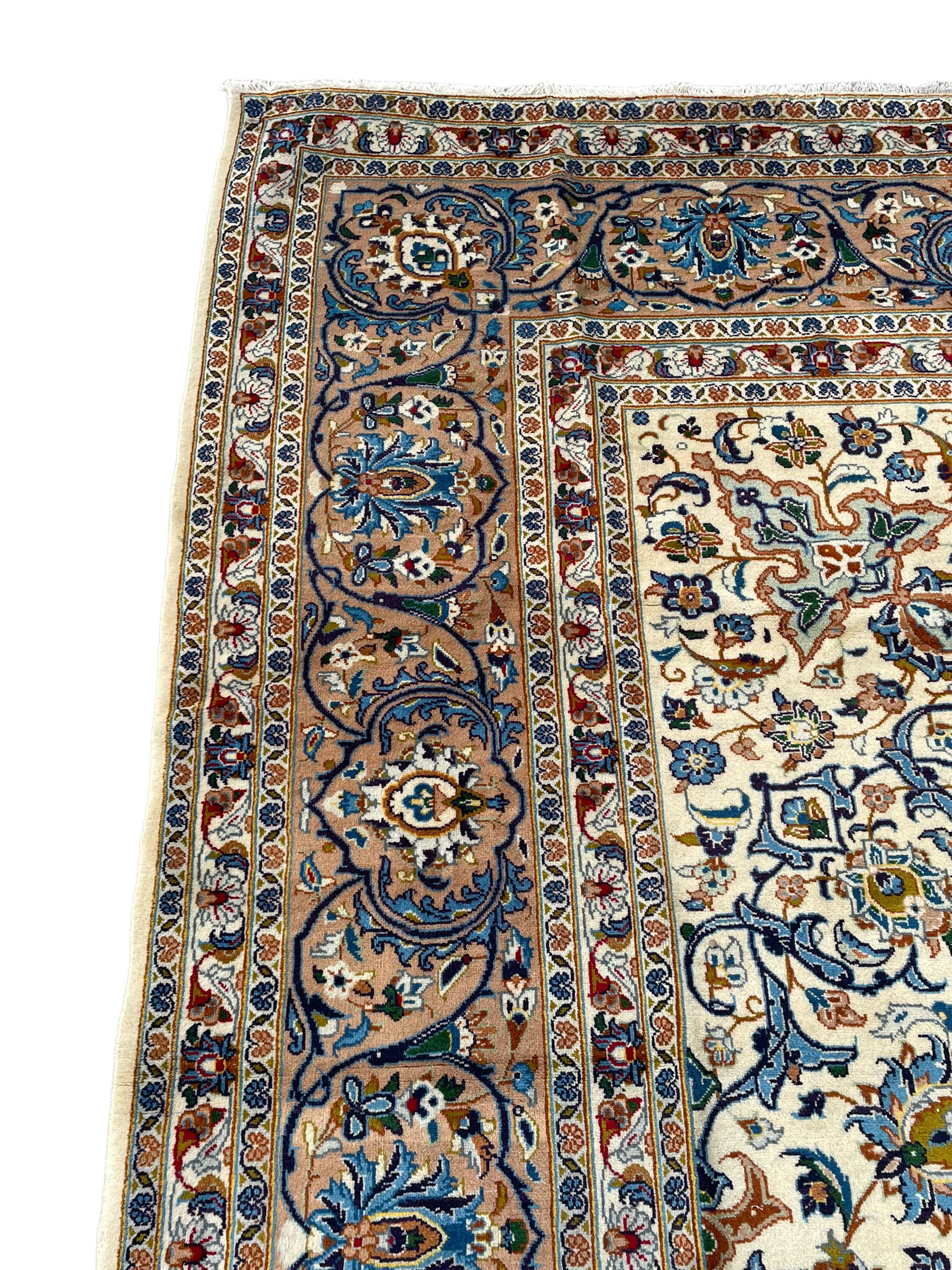 Persian Kashan ivory ground carpet, the interlaced foliate medallion surrounded by trailing plant motifs interlaced with scrolls, the guarded border with repeating stylised flower heads