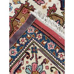 Large Persian carpet, the geometric and stylised floral medallion on rust ground field decorated with stylised plant motifs, guarded ivory border with repeating pattern