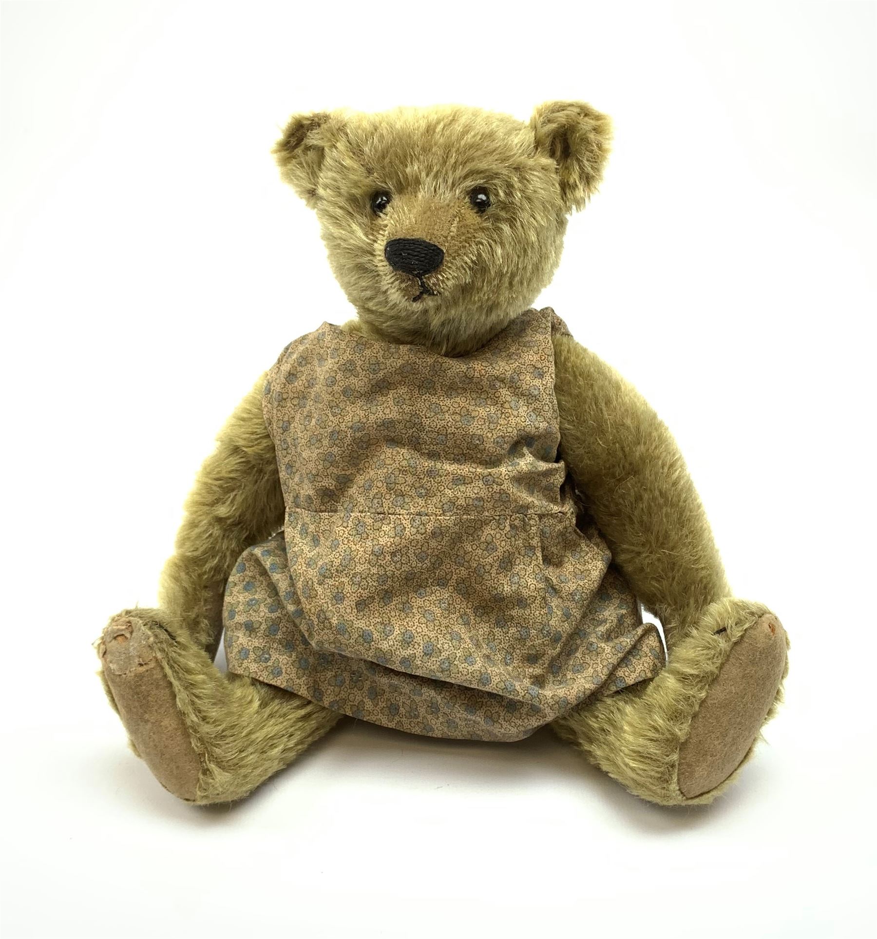 Early 20th century German Steiff teddy bear c1910 with wood wool filled humped back mohair body, swivel jointed head with black boot button eyes and horizontally stitched black nose and mouth, FF metal button to left ear, jointed elongated limbs with felt paw pads and black stitched claws H13