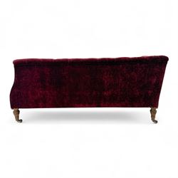 Late Victorian upholstered chaise longue in buttoned red velvet, shaped backrest, on turned walnut legs 