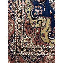 Persian Herati design indigo and red ground carpet, decorated with floral motifs, arched border