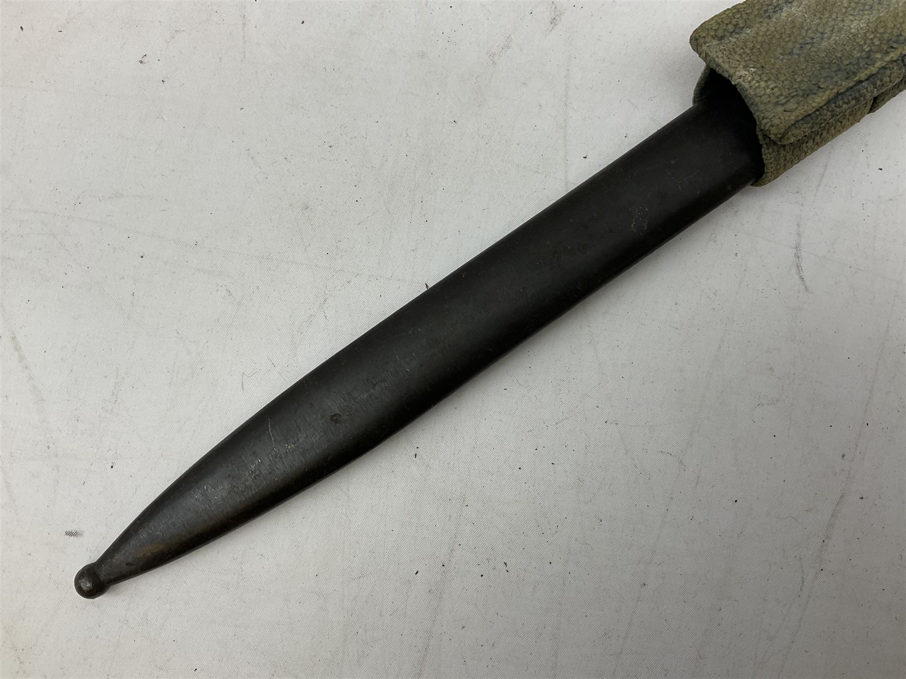 Italian Model 1891 Carcano knife bayonet with 30cm fullered steel blade, the cross-piece stamped VL1110; in steel scabbard with webbing frog L43cm overall; and another Italian fighting knife/bayonet in brass bound leather scabbard (2)