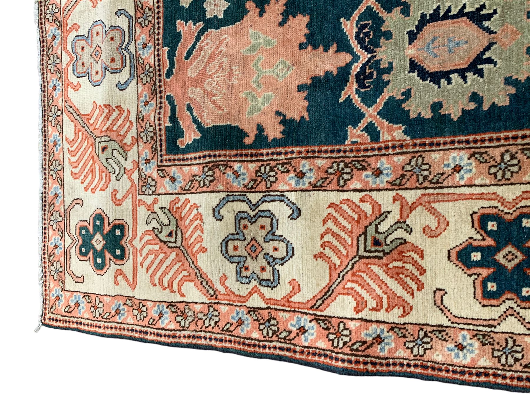 Persian emerald green ground rug, the field decorated with large stylised plant motifs, ivory ground border with repeating leaf motifs, the guards decorated with trailing branch and flowerhead motifs