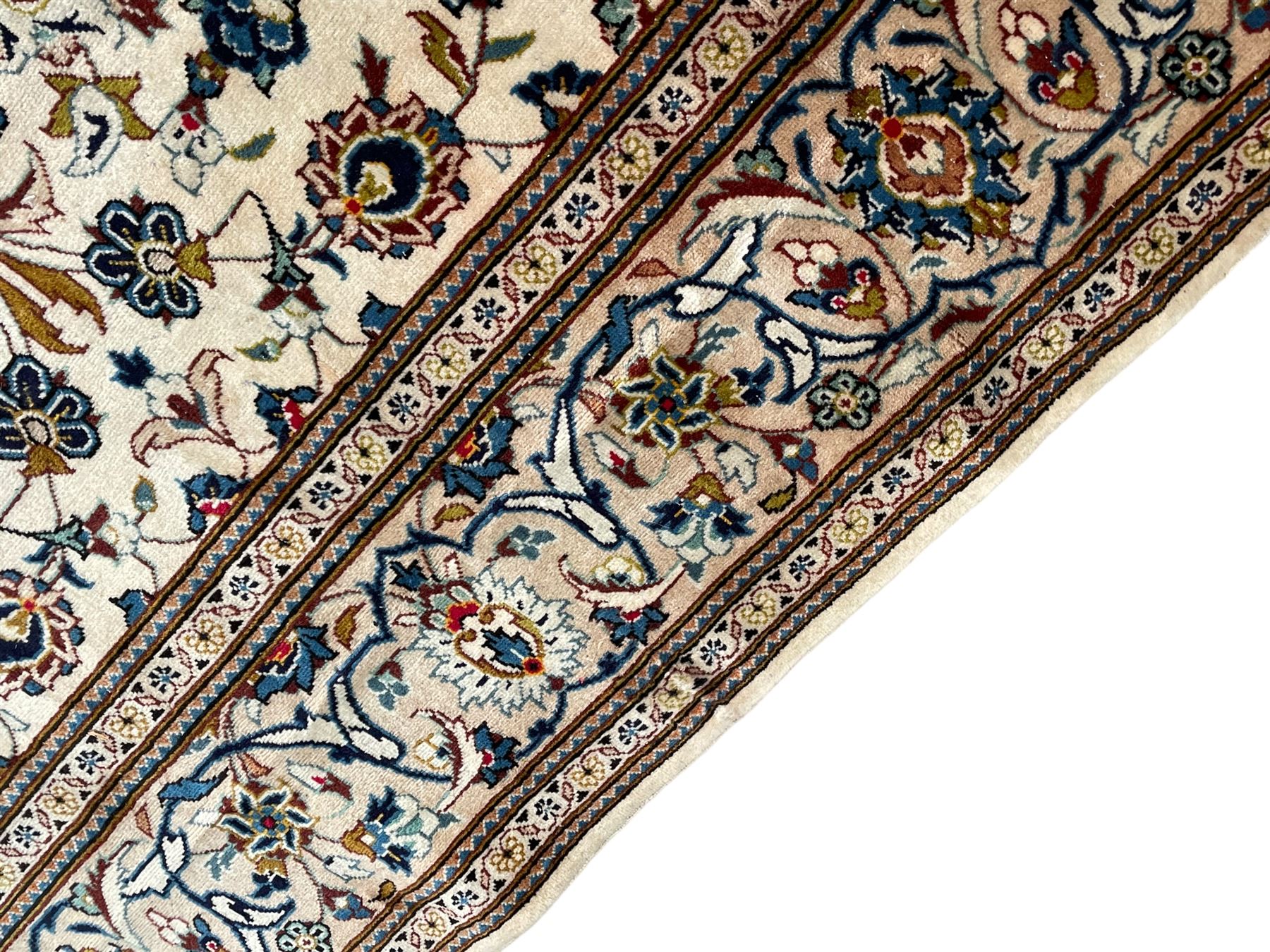 Persian Kashan ivory ground carpet, the field decorated with scrolling branches with foliate and palmette motifs, repeating border with stylised plant motifs, within floral and geometric pattern guard stripes 