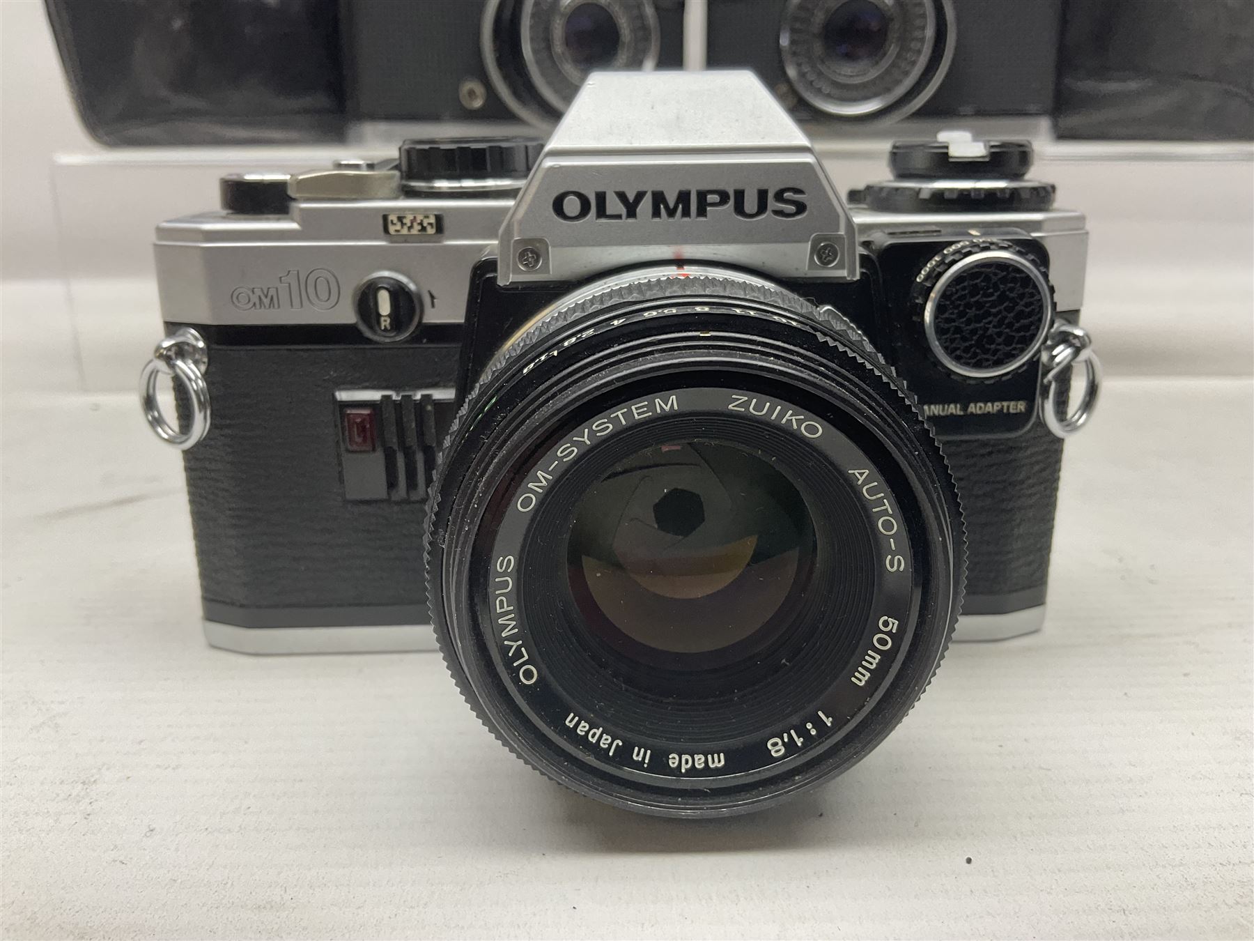 Four Olympus camera bodies, including Olympus OM10, serial no 20744269, with 'Olympus OM-System Zuiko Auto-S 50mm 1:1.8' lens serial no 3633644, Olympus OM-2 camera body serial no 460280 with 'Olympus OM-System G.Zuiko Auto-s 1:1.4 f=50mm' lens, serial no 729750, etc 
