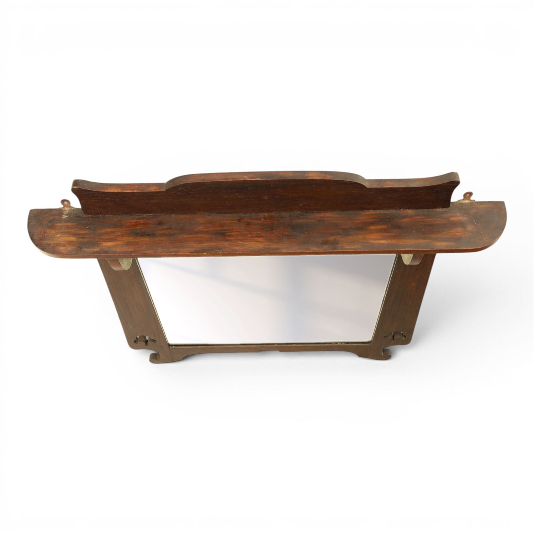 Arts and Crafts oak wall mirror, rectangular mirror plate within shaped frame, raised shelf with shaped back and pierced heart detail, bracket supports and shaped lower rail