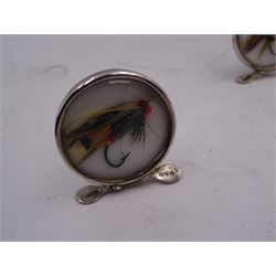 Set of four early 20th century silver mounted place card holders, each of circular form and set with a coloured fly fishing hook behind a glazed panel, upon three pad feet, hallmarked Grey & Co, Chester 1912, H4.5cm, contained within red fitted case, with purple silk and velvet interior