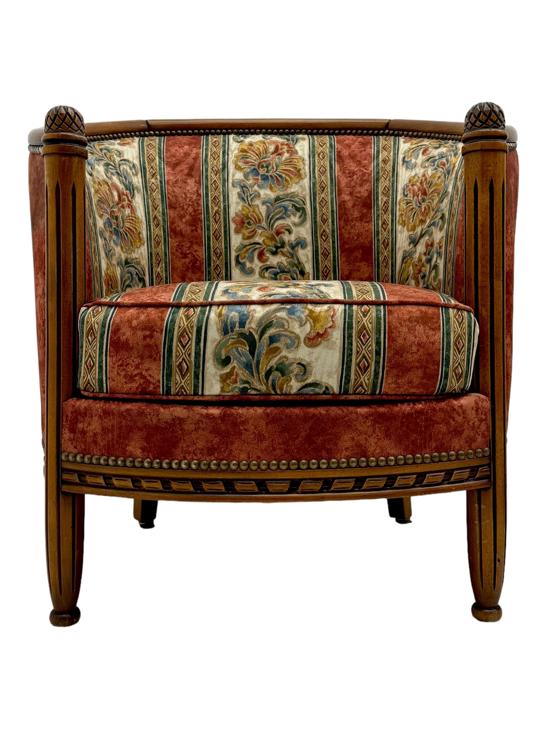 Pair of cherry wood framed tub-shaped armchairs, upholstered in striped floral fabric with brass stud trim, carved walnut frame with fluted supports capped with pinecone finials, on turned feet