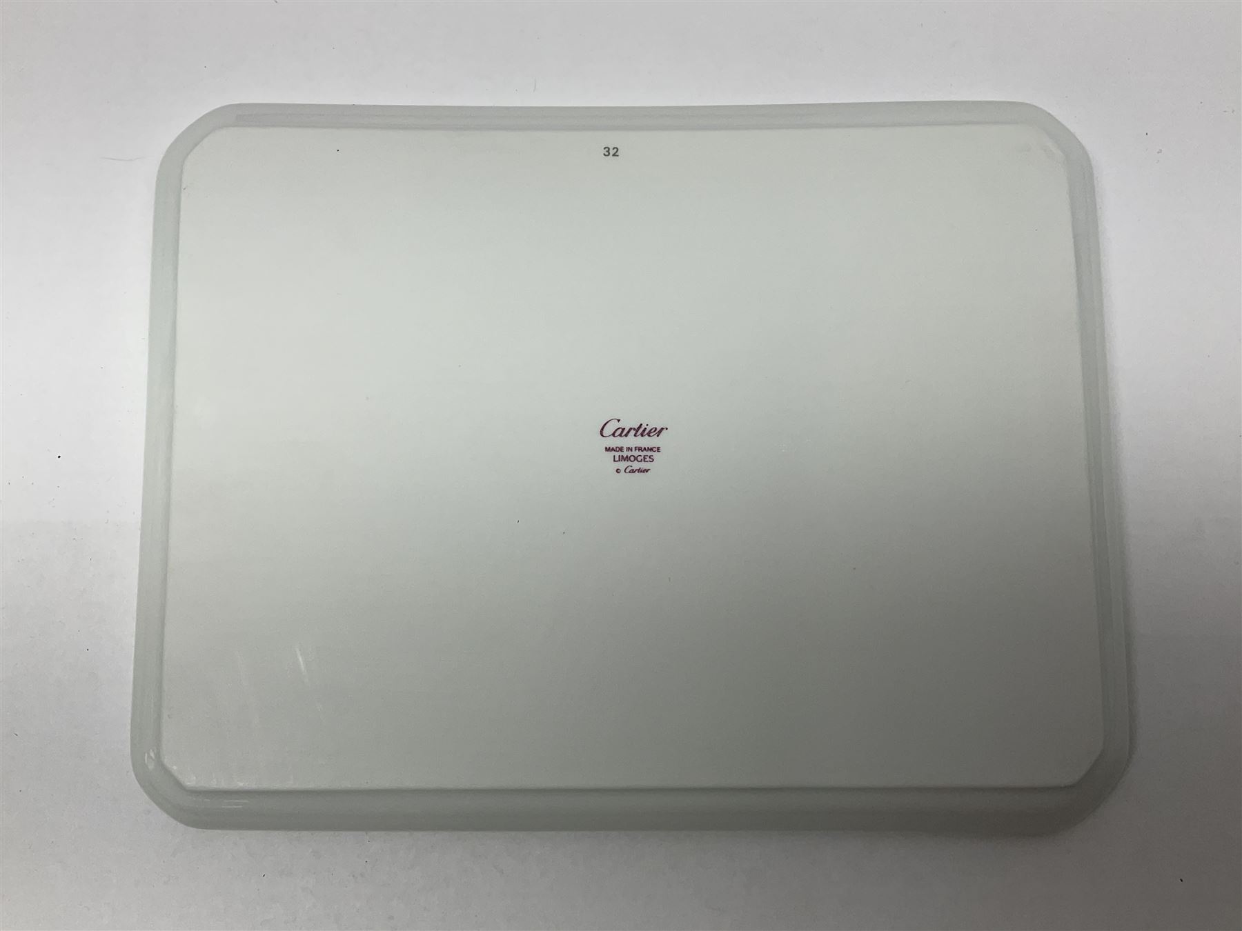 Limoges for Cartier, ceramic trinket dish, of rectangular form with rounded corners, decorated to centre with leopard upon a blue ball, with blue and gilt rim, with printed mark beneath, in original box, H15.5cm, W21cm