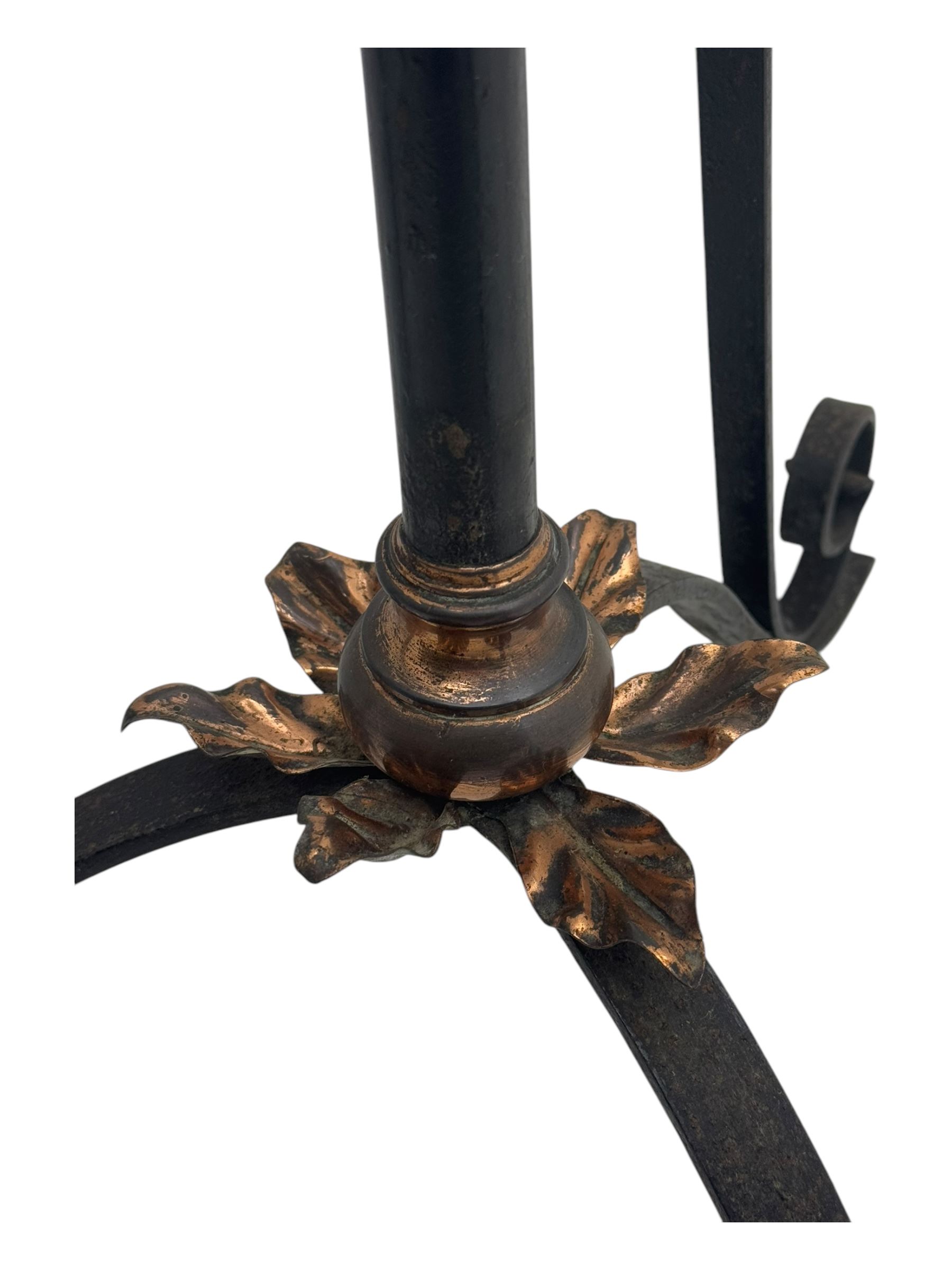 Late 19th century wrought iron and brass pulpit lamp, featuring an adjustable stem with a spiral twist detail, brass foliate mounts, and a tripod base with scrolled feet and decorative floral accents