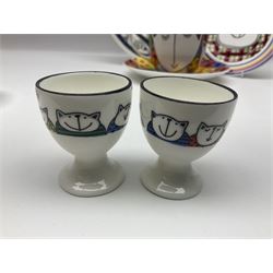 Modern studio pottery by Josie Firmin, to include cup and saucer, three espresso cups and saucers, pair of egg cups etc, each hand painted with varying cartoon cat designs