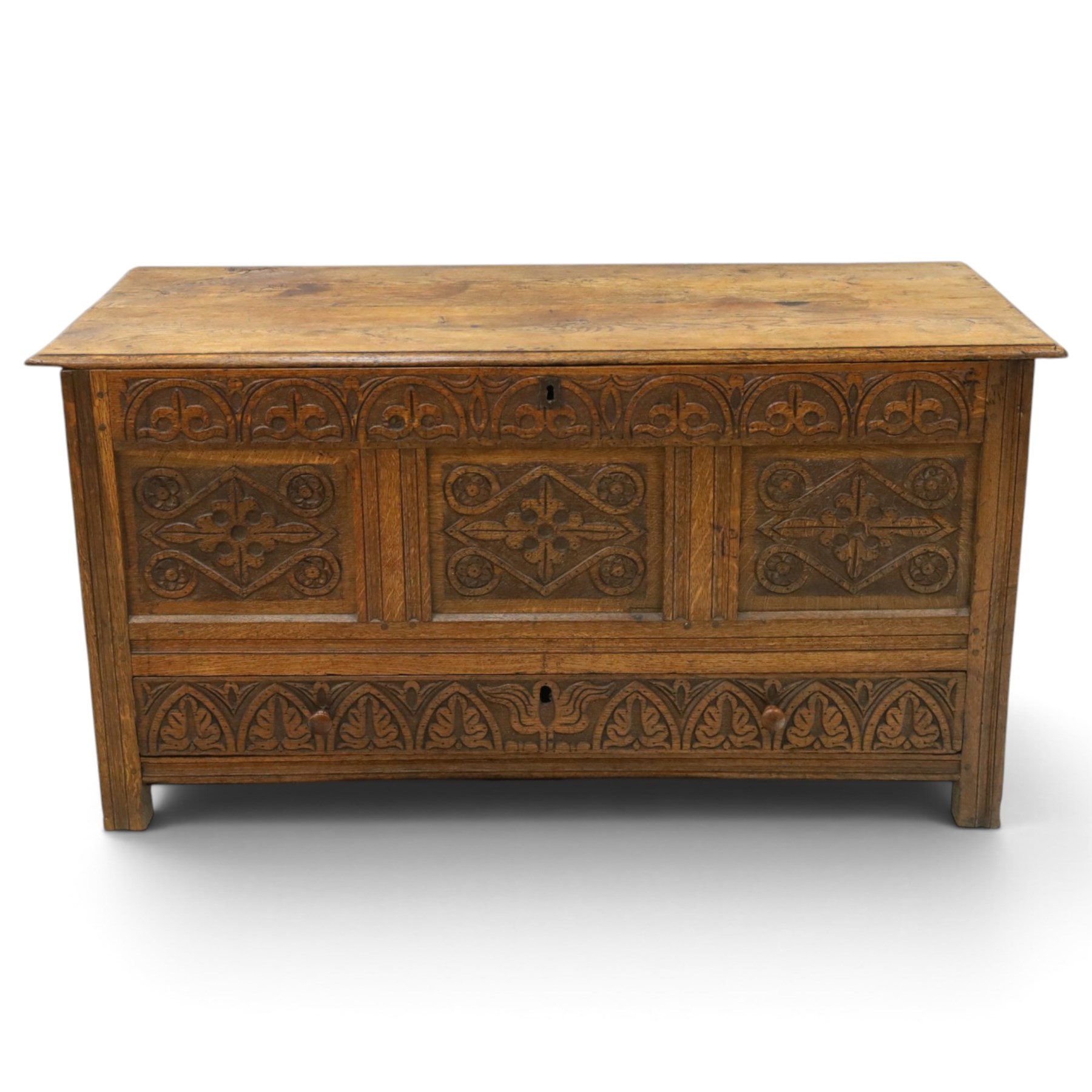 18th century carved oak coffer, rectangular hinged top over a lunette-carved frieze and tracery-style carved triple panelled front, the lower rail carved with repeating anthemion motifs, on square feet