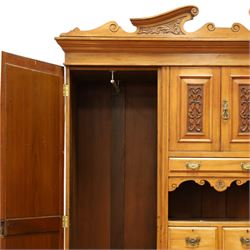 Edwardian walnut triple combination wardrobe, projecting pediment with pierced foliate scroll cresting above a central cupboard flanked by bevelled mirrored doors, over open recess with mirrored back, above two short and three long drawers with brass handles, interior fitted with hanging rails and shelf, raised on plinth base