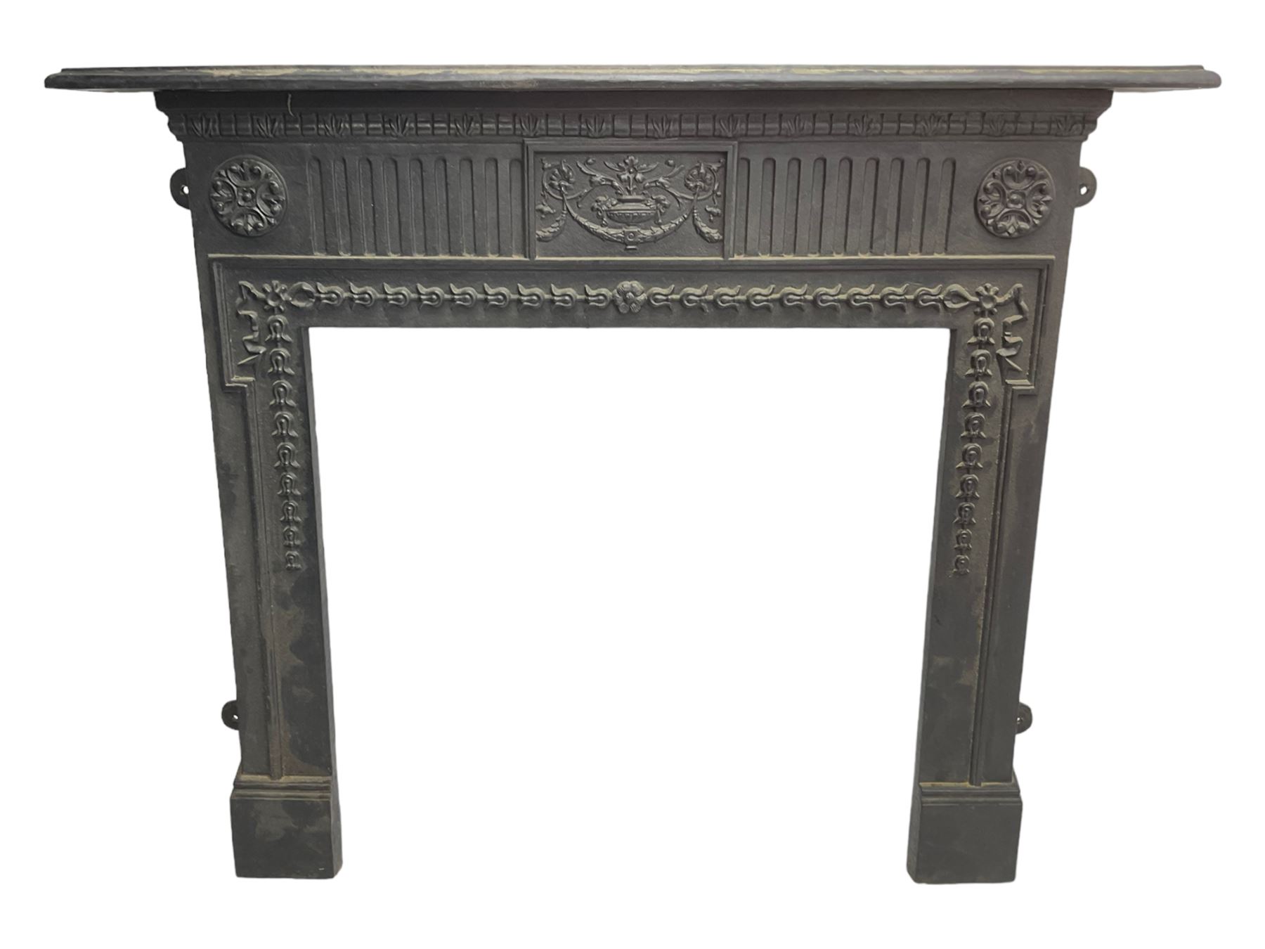 Adam design - cast iron fire surround, moulded rectangular mantel over central foliate urn and vertical flutes, flanked by C-scroll floral roundels, the aperture decorated with trailing bellflowers