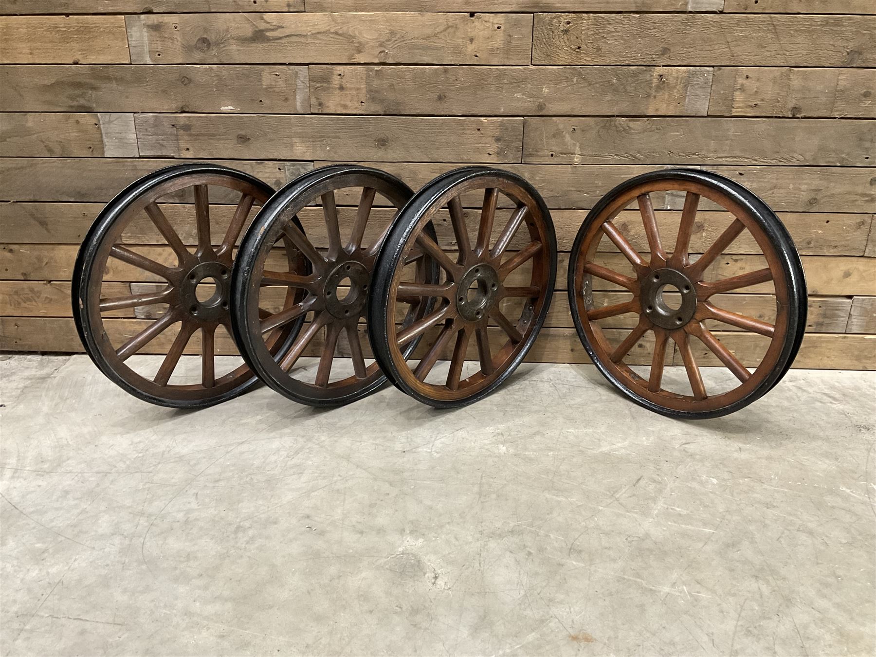 Set of four wheels from an early 20th century cart, wood with metal outer