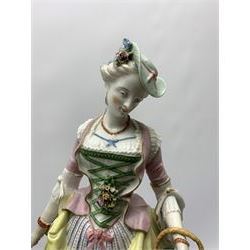 Pair of large 19th century Jacob Petit figures, in the style of Meissen's Gardener and companion, each modelled in 18th century dress and holding posy in the one hand and basket of flowers in the other, upon circular floral encrusted bases, each with spurious blue crossed sword marks beneath, the male figure also marked with blue underglaze mark 'JP', tallest H46cm