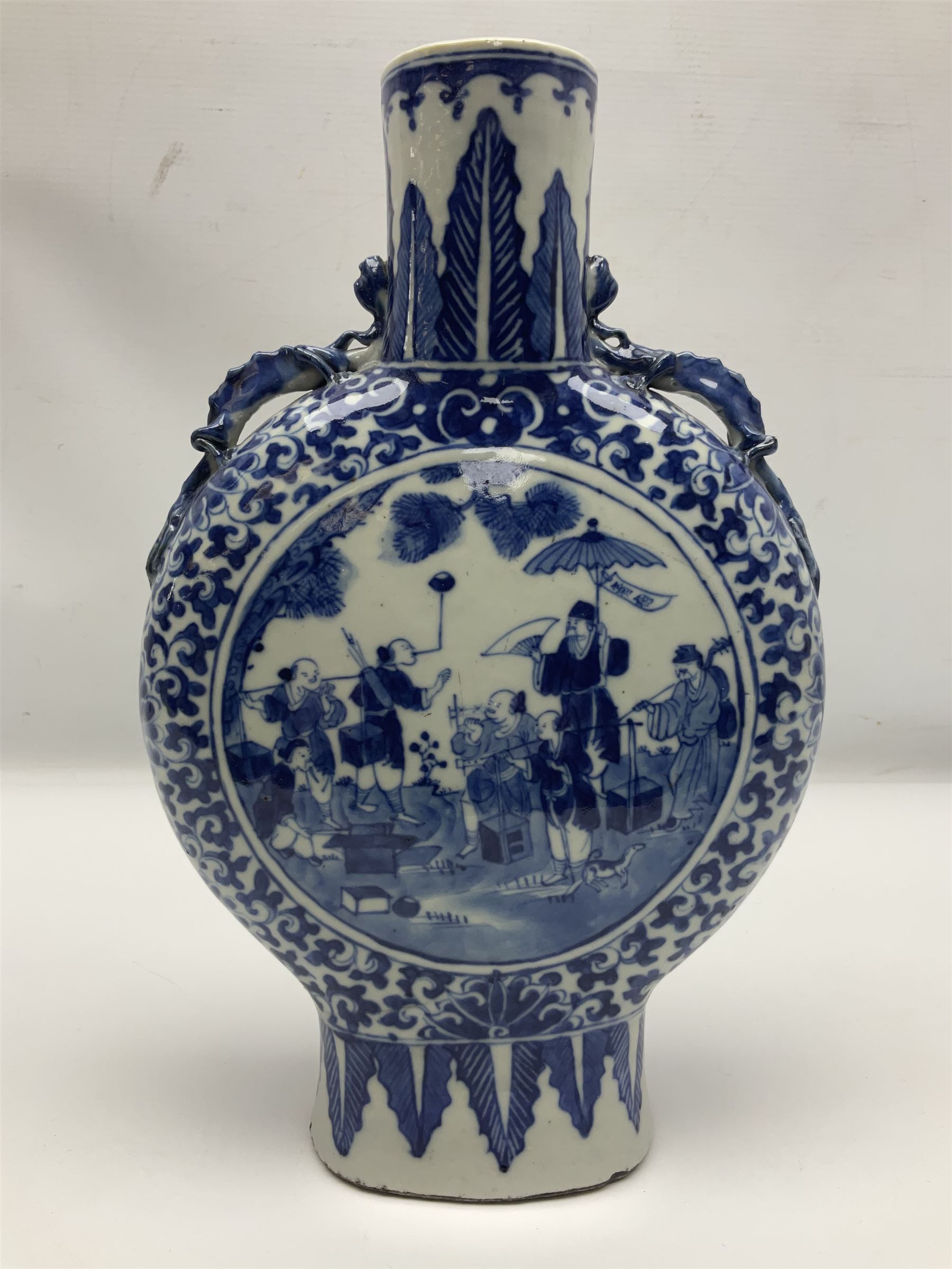 19th century Chinese blue and white moon flask vase, the central panel depicting musicians, bordered by floral, foliate and scroll decoration, with lizard handles to each shoulder, upon an oval foot, H31cm 
