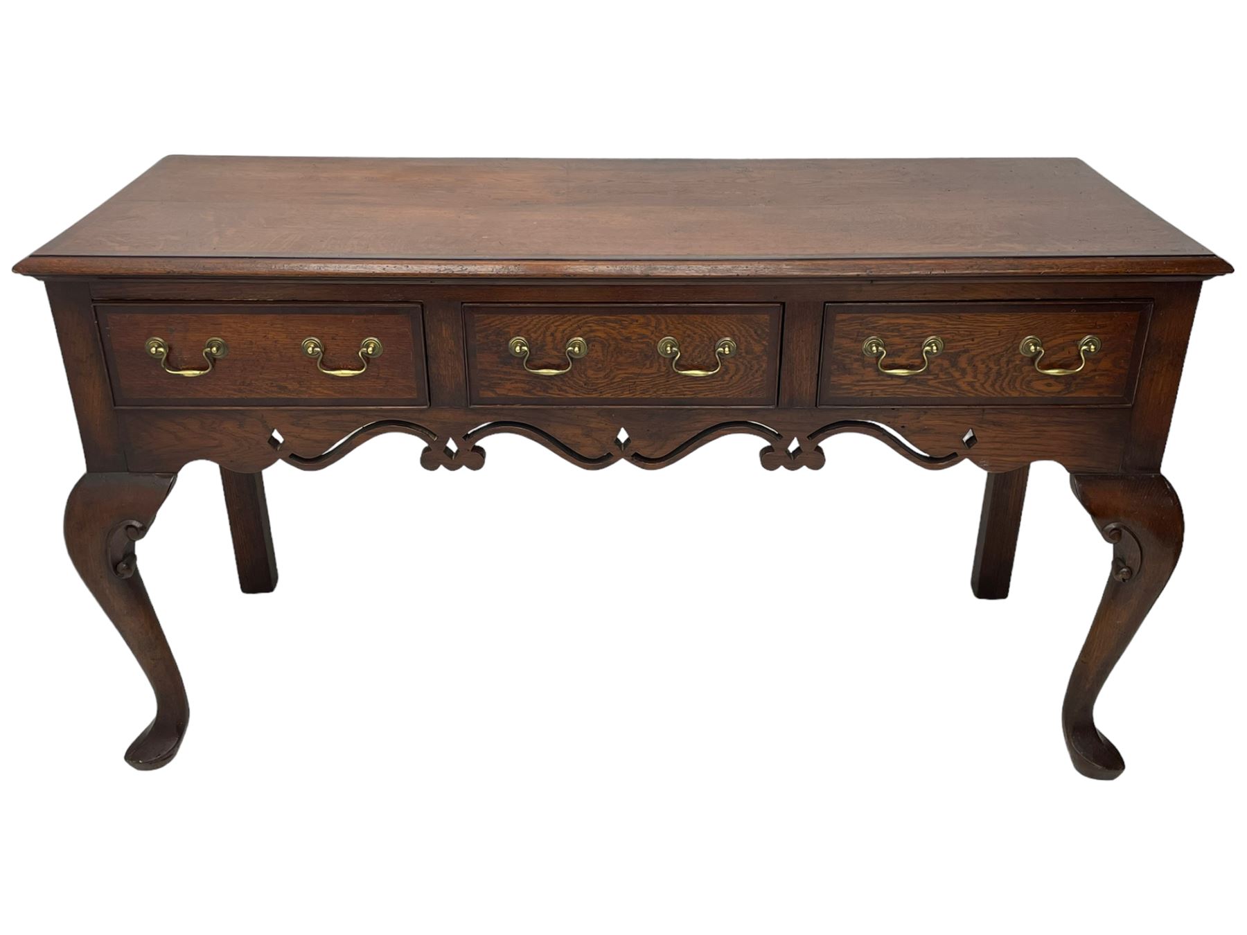 Georgian design oak and mahogany dresser base, the rectangular moulded top with mahogany band, three cocked-beaded and banded drawers over shaped a pierced apron, circular brass handle plates and swan neck handles, on C-scroll carved cabriole supports 