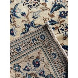 Persian Kashan ivory ground rug, the field decorated with trailing branches with leaves and palmettes, similar scrolling border, within floral pattern guard stripes 