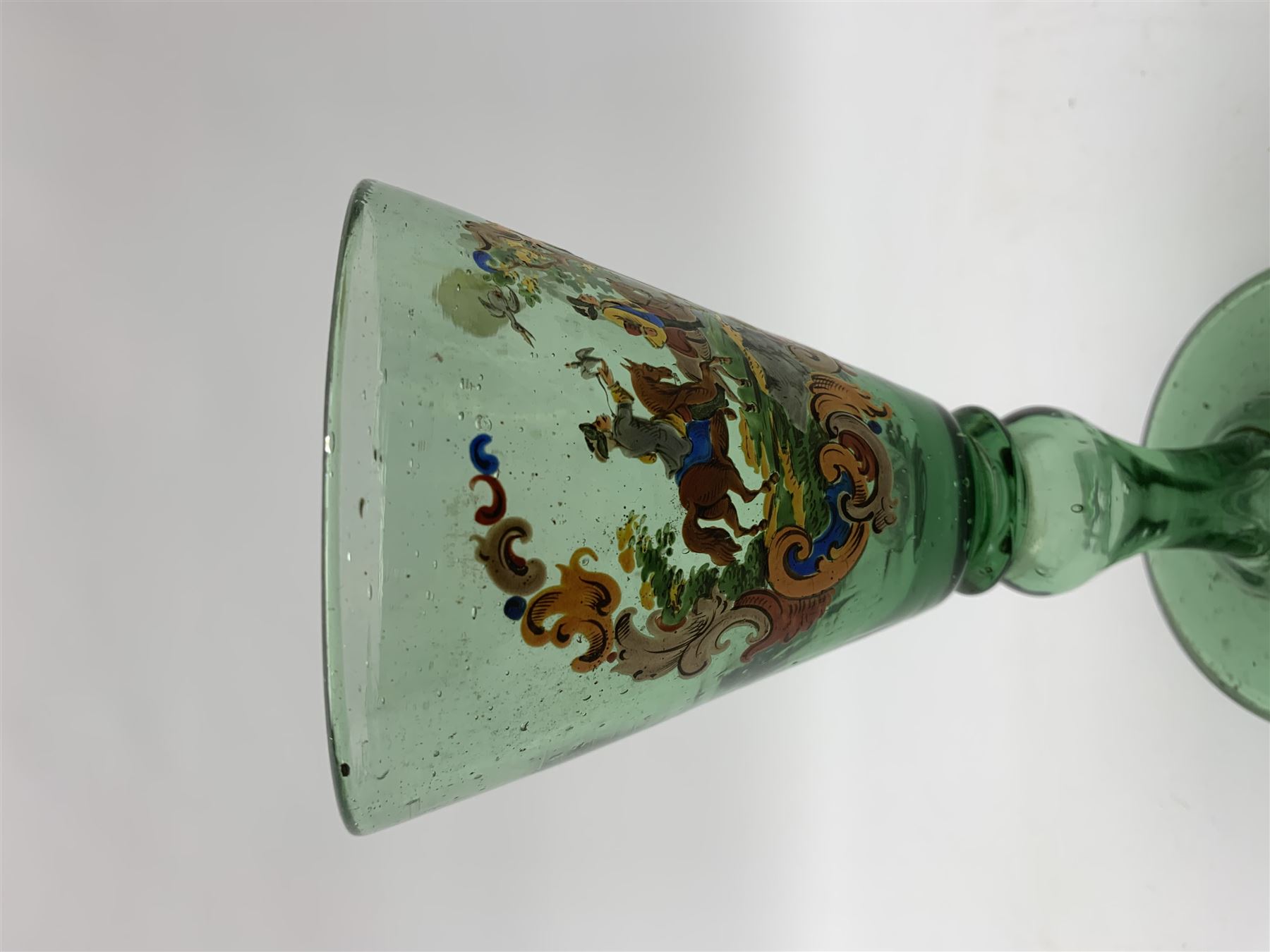 19th century bohemian green glass wine glass, the funnel bowl decorated in enamells with a Historismus hunting scene in the manner of Egermann & Lobmeyr, upon a baluster stem and circular foot, H14.5cm